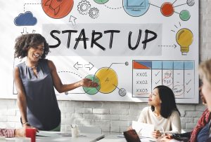 a group of people standing in front of a whiteboard with the words start up.